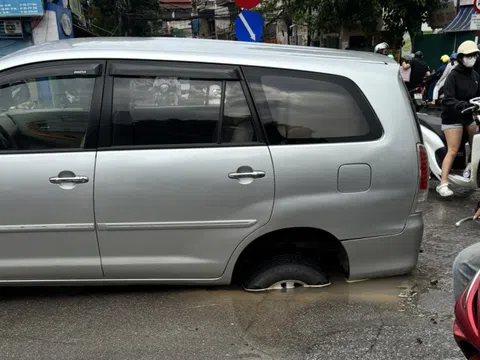 Xe 7 chỗ 'đứng bánh' giữa đường ở Hà Nội vì sụp hố